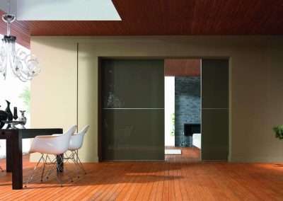 Sötét színű festett üveggel készített térelválasztó hálószoba és nappali között