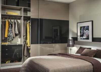 Barna színű, meleg, barátságos hálószoba szekrénnyel és egyedi készítésű ággyal